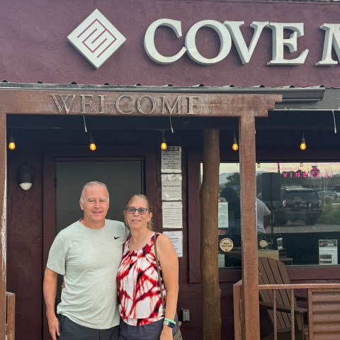 Two people standing in front of Cove Mesa building entrance.